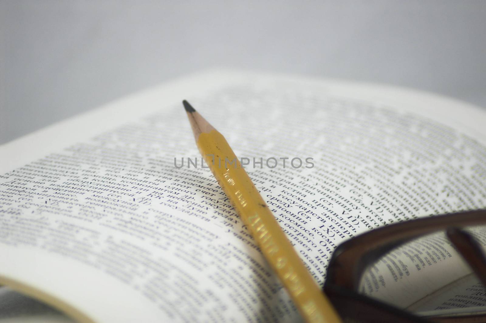 Pencil and glasses on a book by javax