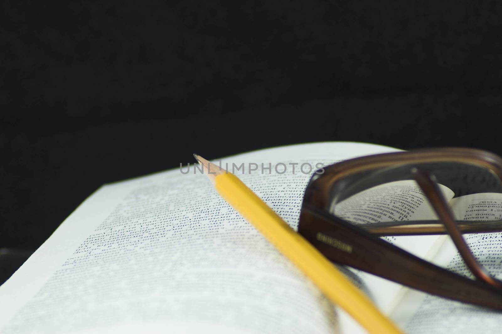 Pencil and glasses on a book by javax