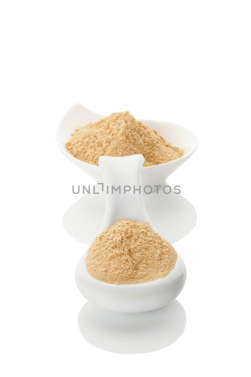 Maca powder on spoon and in a bowl isolated on white background. Natural alternative medicine.