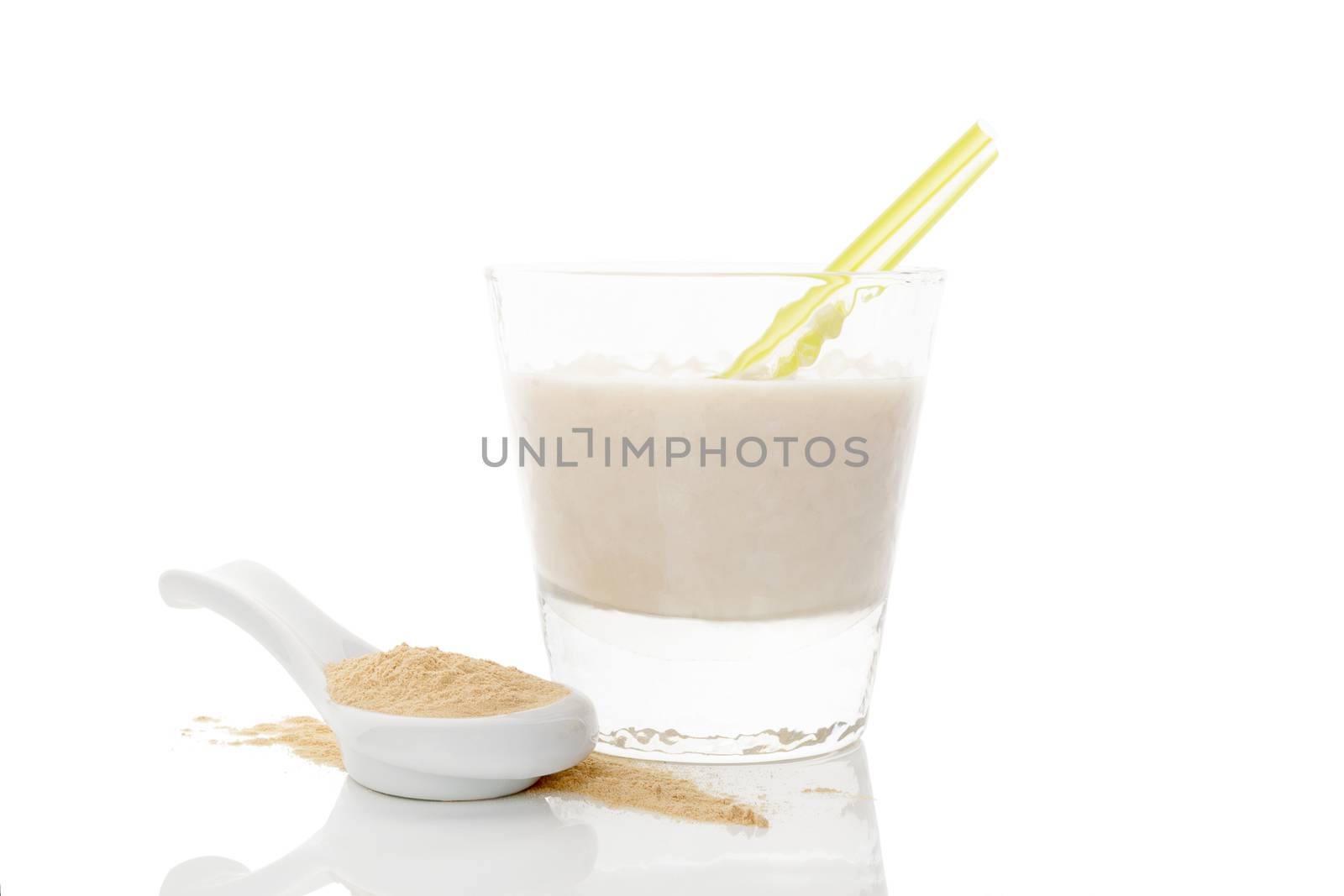 Maca powder on spoon and maca milkshake in glass isolated on white background. Natural alternative medicine.