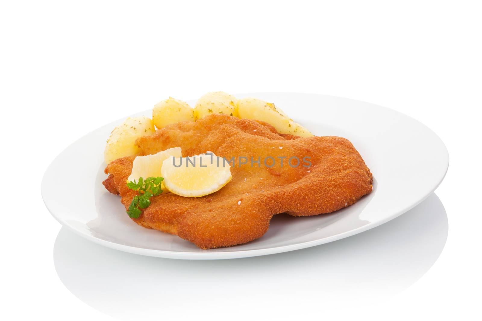 Delicious wiener schnitzel on plate isolated on white background with reflection. Traditional european cuisine.