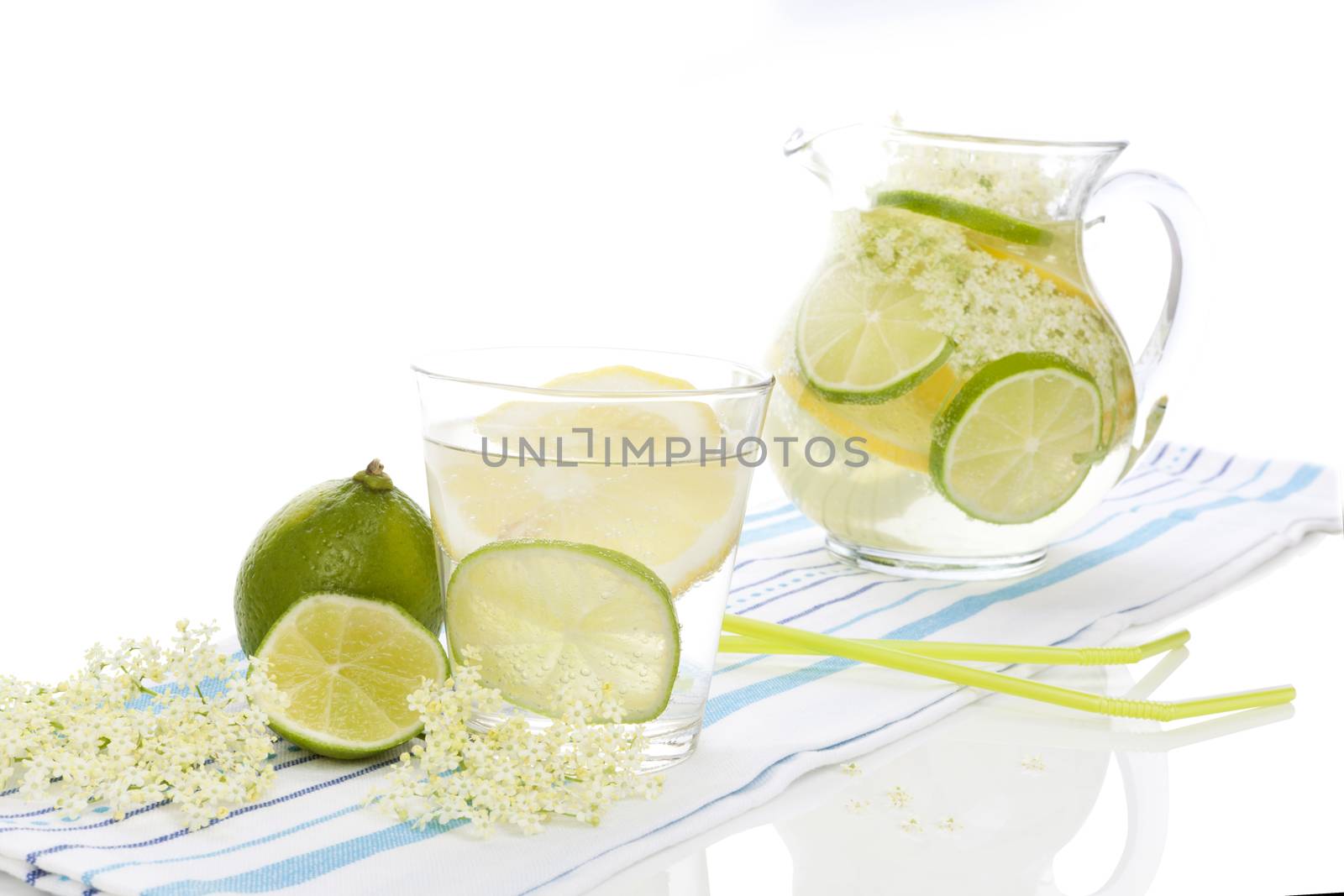 Healthy homemade organic elderberry lemonade with lime slices isolated on white background. Refreshing seasonal nonalcoholic summer drink.