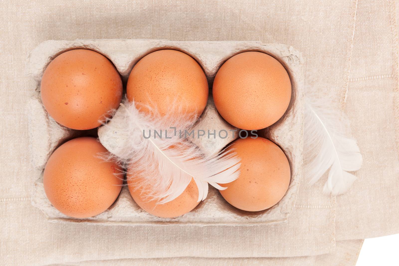 Organic chicken eggs in paper box isolated on white background, top view.