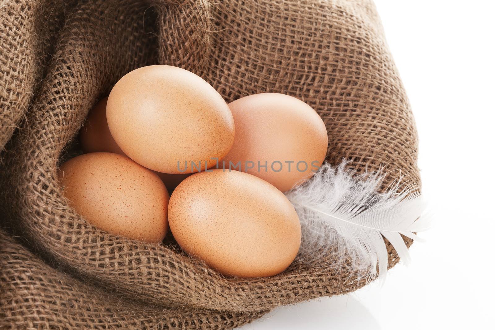 Organic chicken eggs in burlap bag isolated on white background.