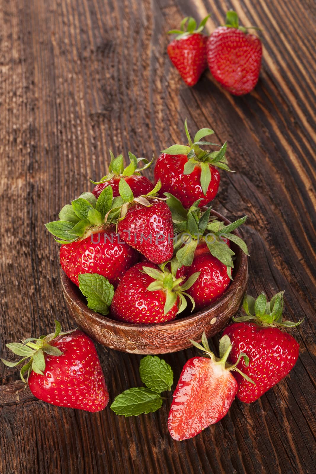 Ripe strawberries on rustic wooden brown table. Healthy fruit eating.