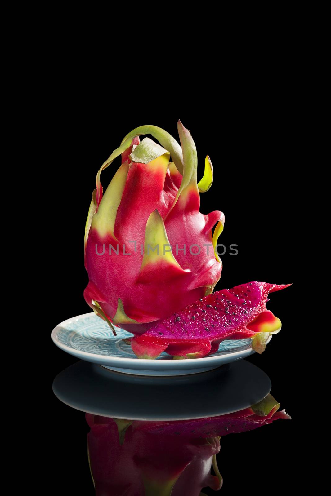 Delicious ripe red dragon fruit isolated on black background. Tropical fruit, pitaya concept. Healthy eating. 