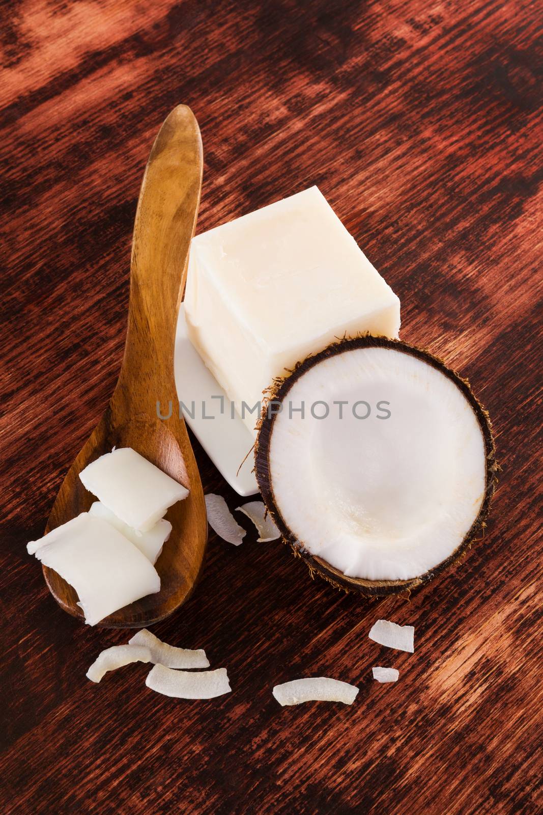 Coconut oil background. Hard coconut oil, coconut flakes and coconut on brown wooden background. Healthy ecological living.