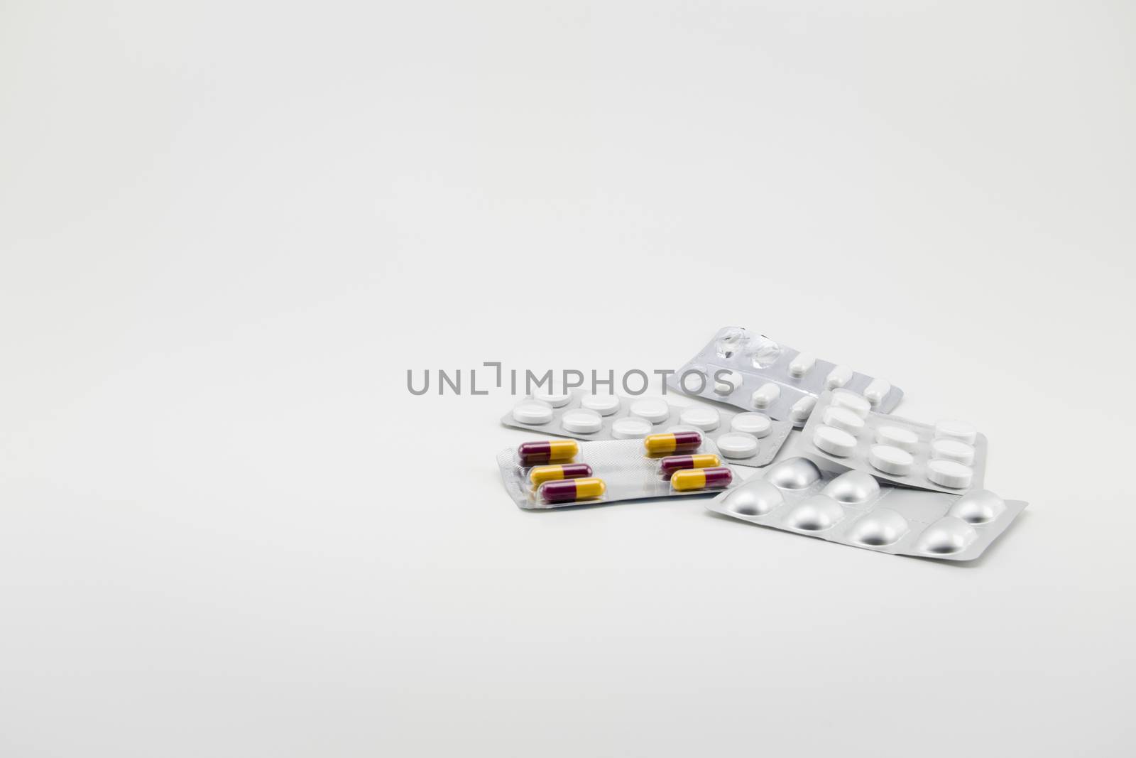 Capsules and pills packed in blisters, isolated on white