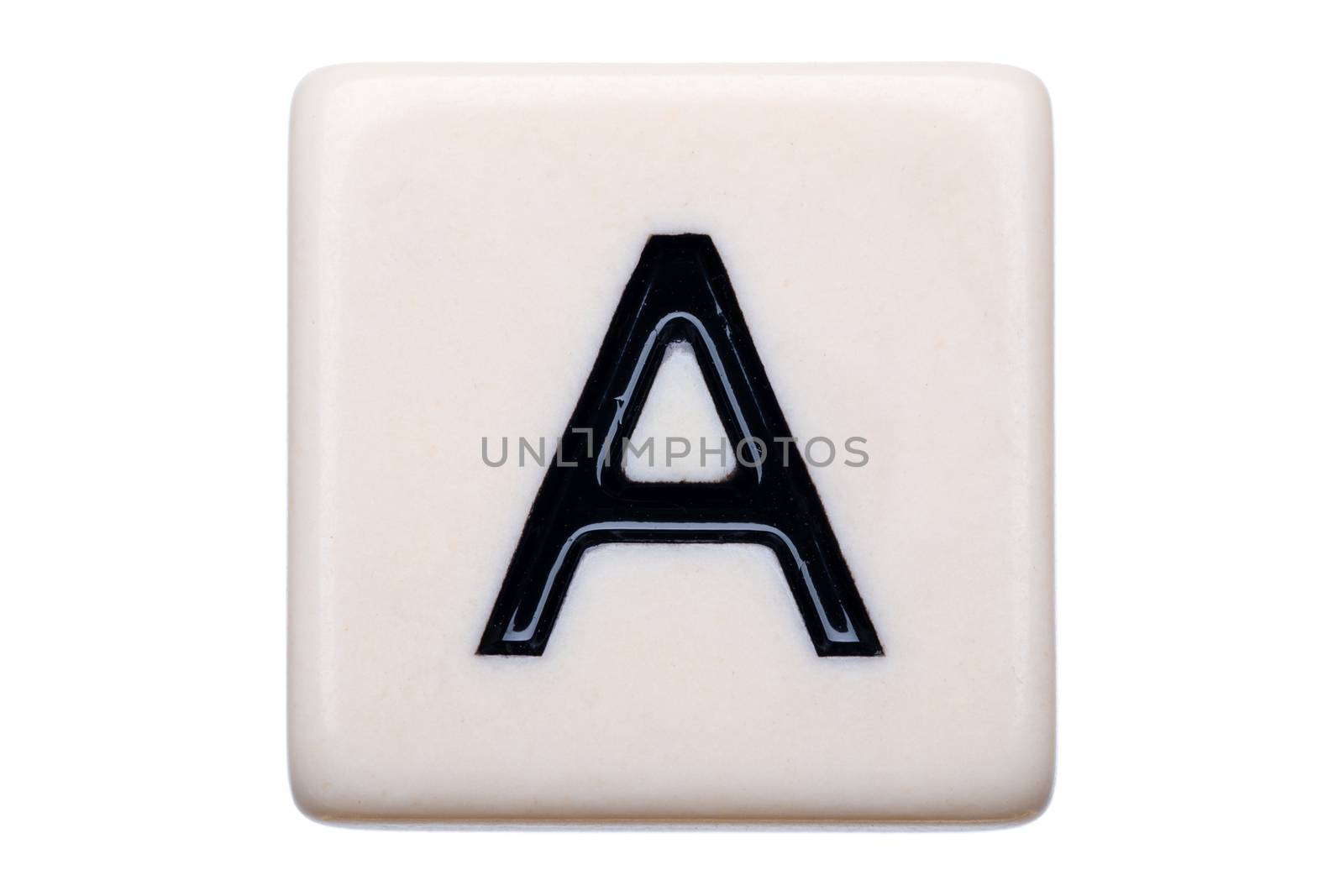 A macro shot of a game tile with the letter A on it on a white background.