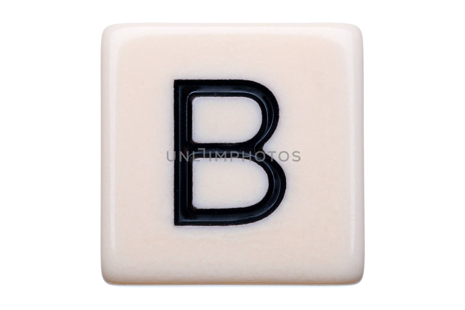 A macro shot of a game tile with the letter B on it on a white background.
