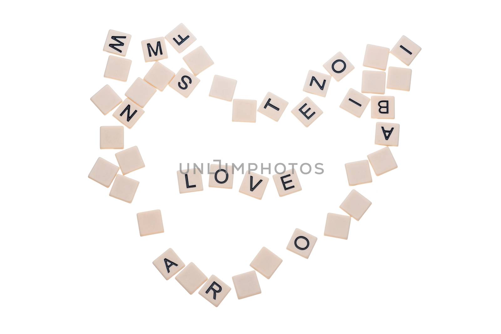 Small game tiles with letters on them arranged in a heart surrounding the word "love" isolated on a white background.