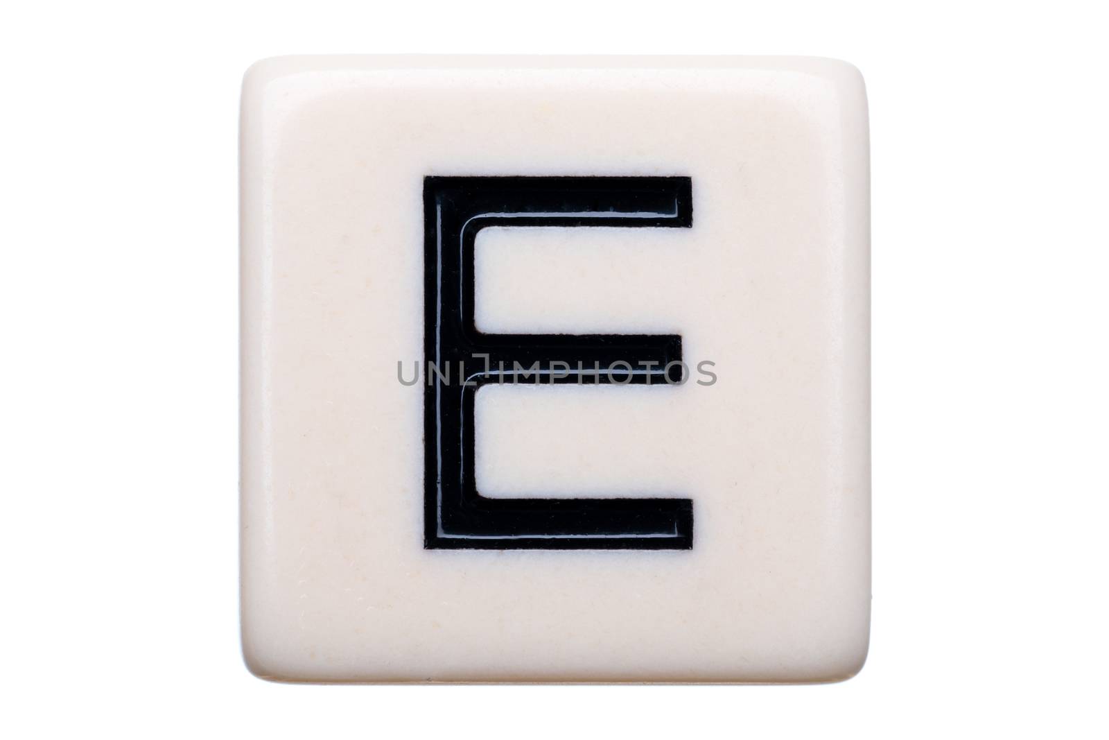 A macro shot of a game tile with the letter E on it on a white background.