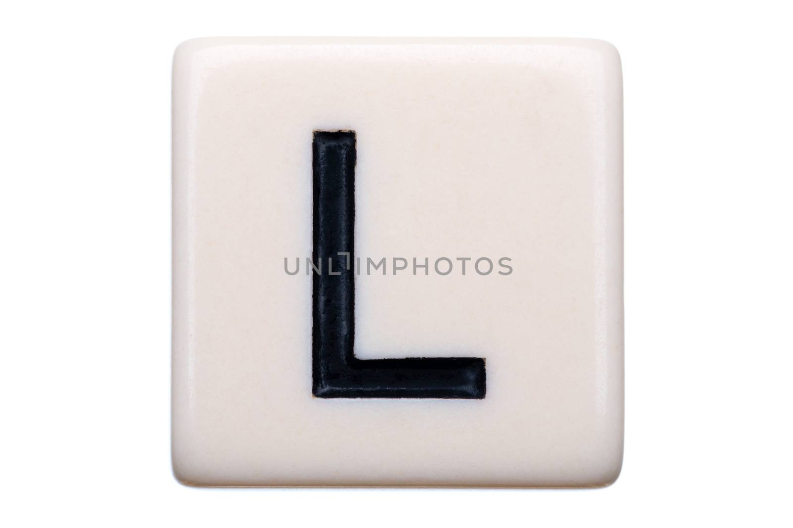 A macro shot of a game tile with the letter L on it on a white background.