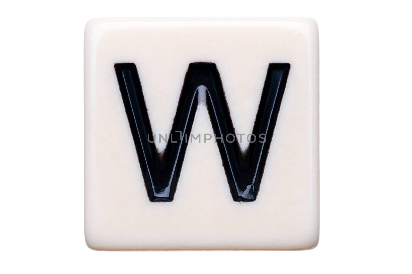 A macro shot of a game tile with the letter W on it on a white background.