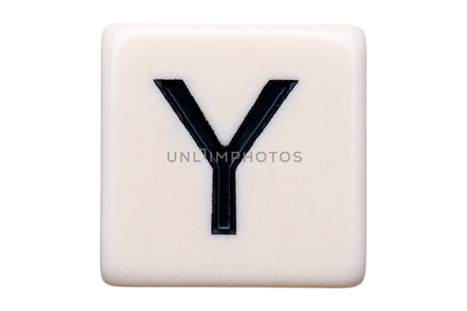 A macro shot of a game tile with the letter Y on it on a white background.