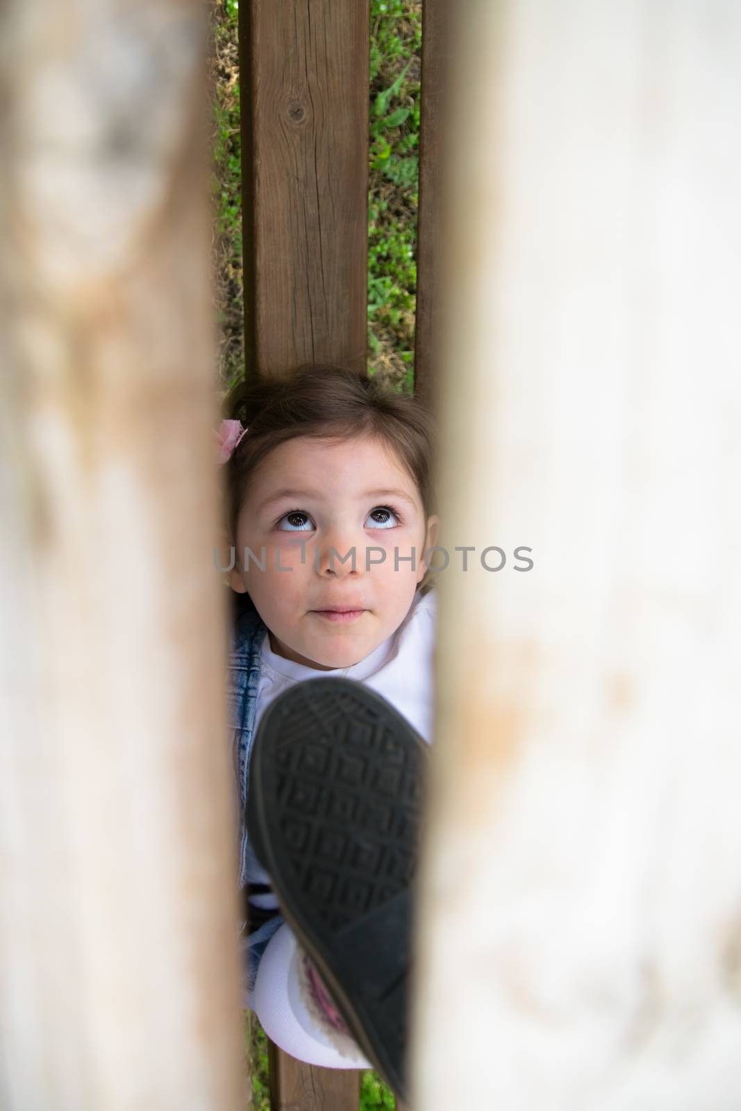 child plays in a wooden outdoor playground