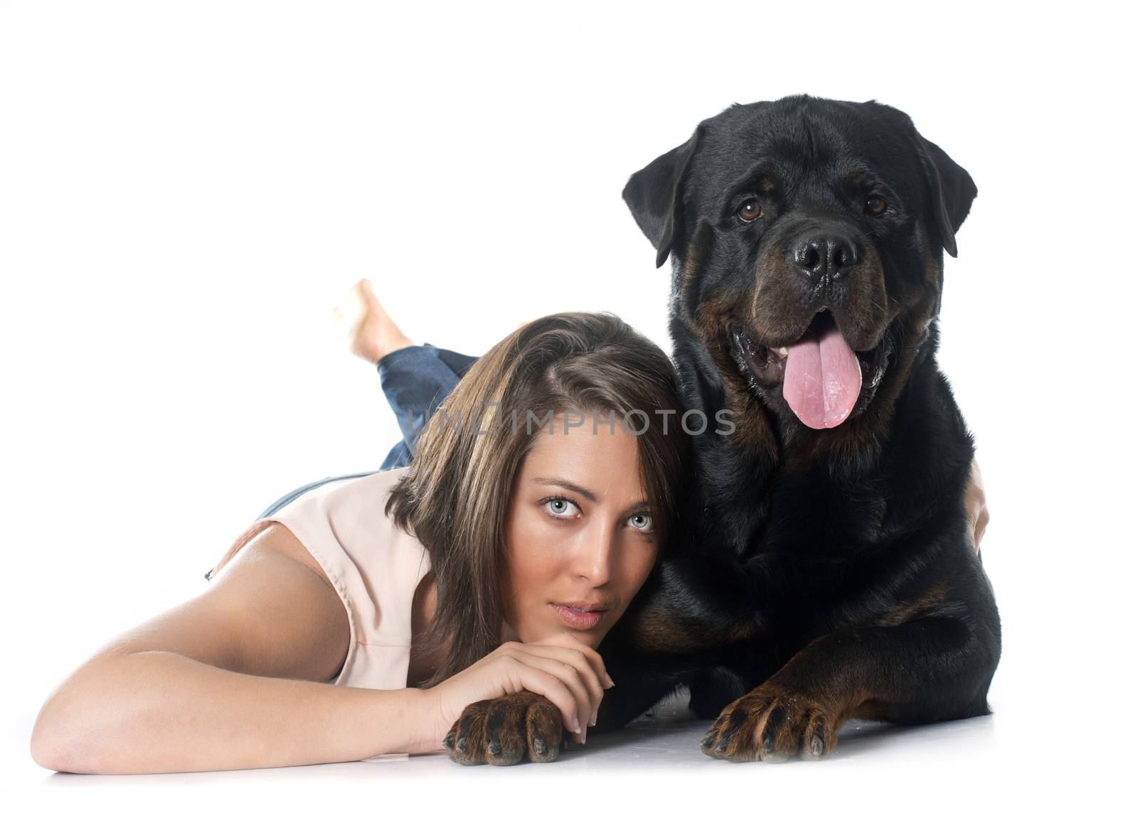 young woman and rottweiler in front of white background