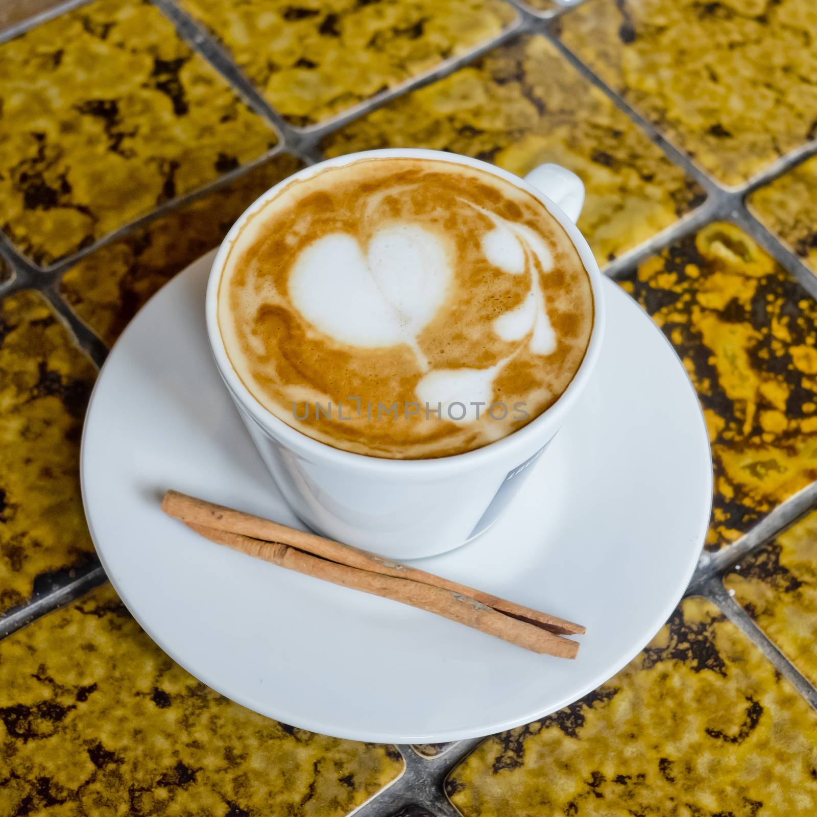 A cup of cafe latte and Cinnamon stick.
