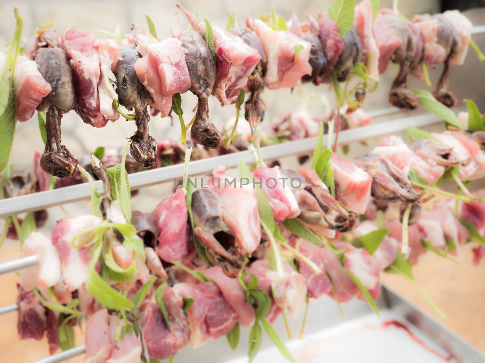 birds on the spit with meat, bacon and sage ready for roasting