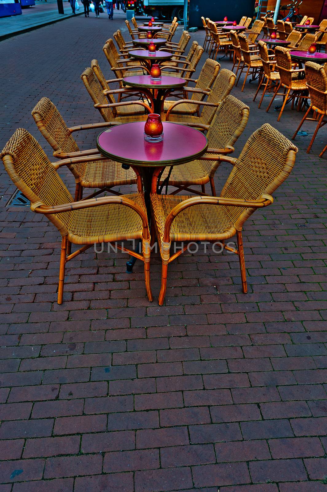Wicker Chairs and Tables in a Street Cafe at Night