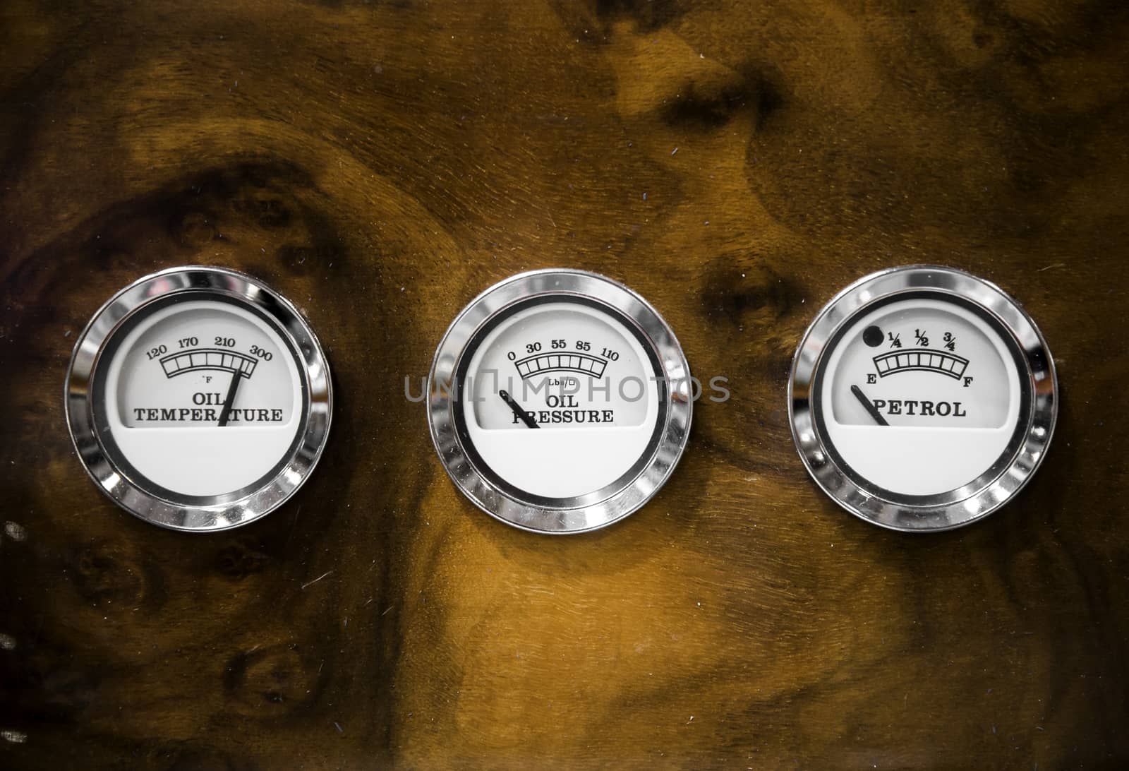 wooden dashboard of a classic car with three indicators