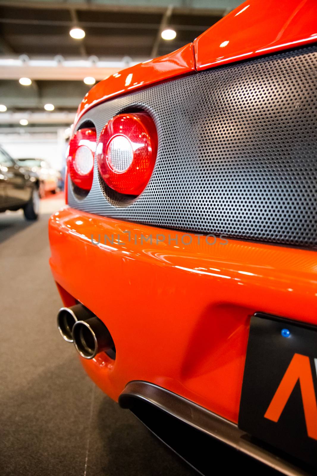 exhaust pipes and tail lights of a bright orange sports car