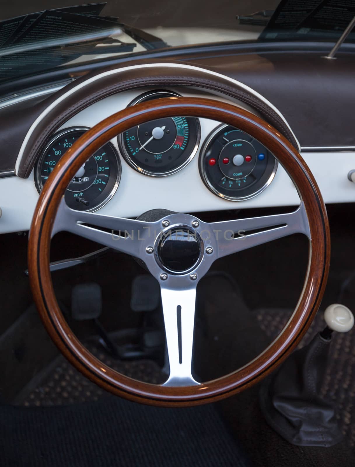 wooden steering wheel and brown leather dashboard of a classic vintage car