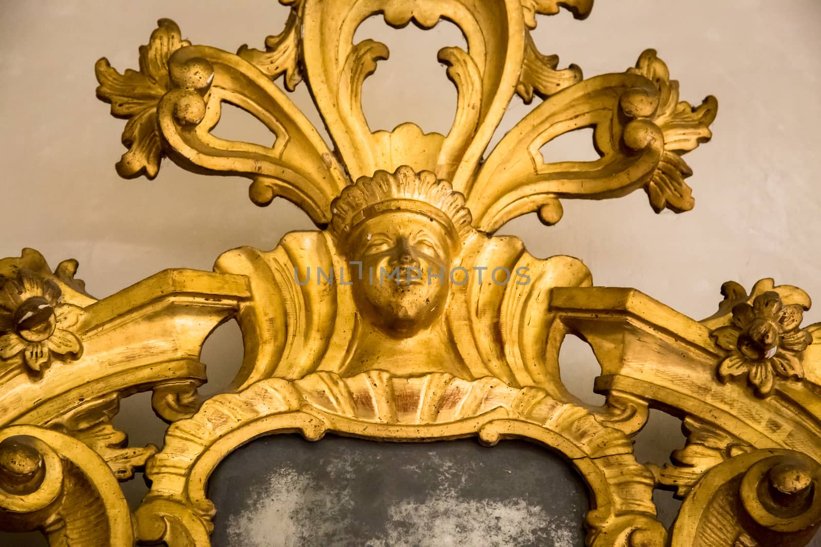 detail of a carved gilded frame of an antique mirror