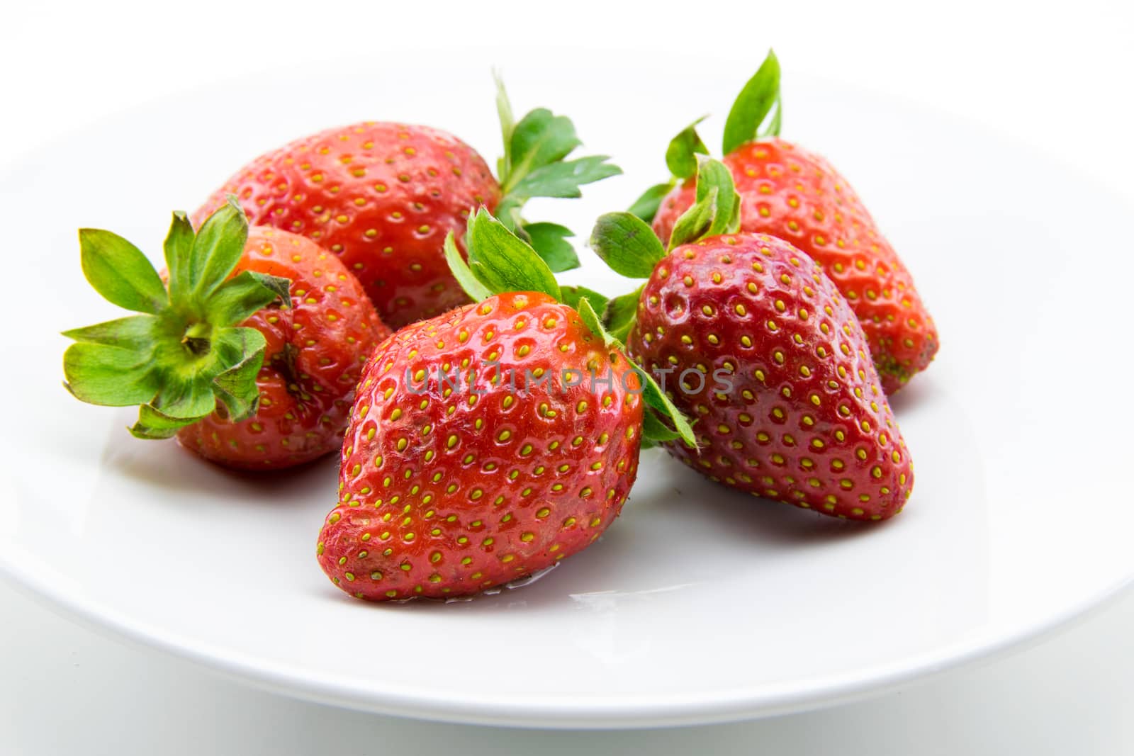 red strawberries freshly picked on white background