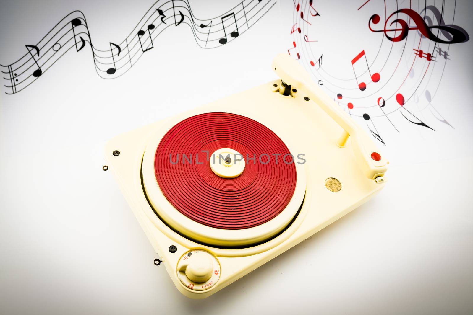 composition with vintage red record player and musical notes on background