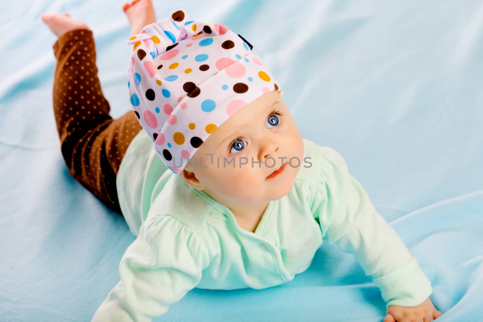 Charming baby girl in a hat. Studio