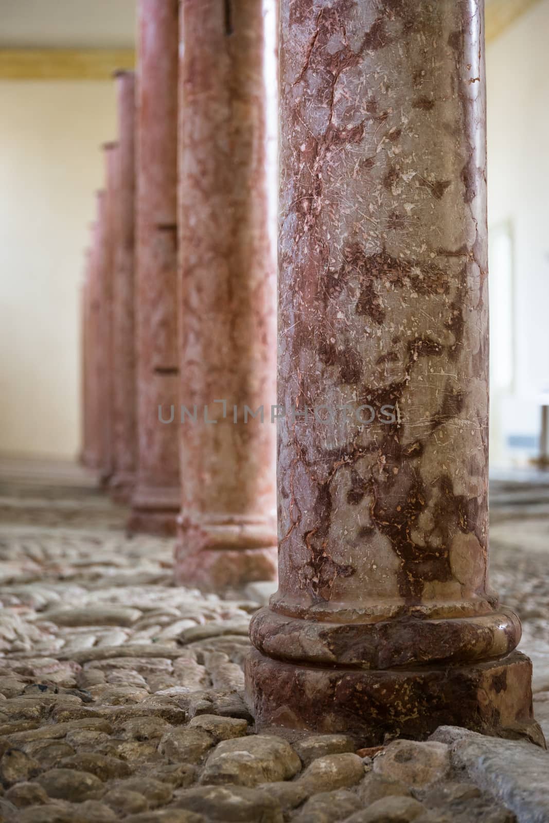 antique red marble columns resting on stone floor