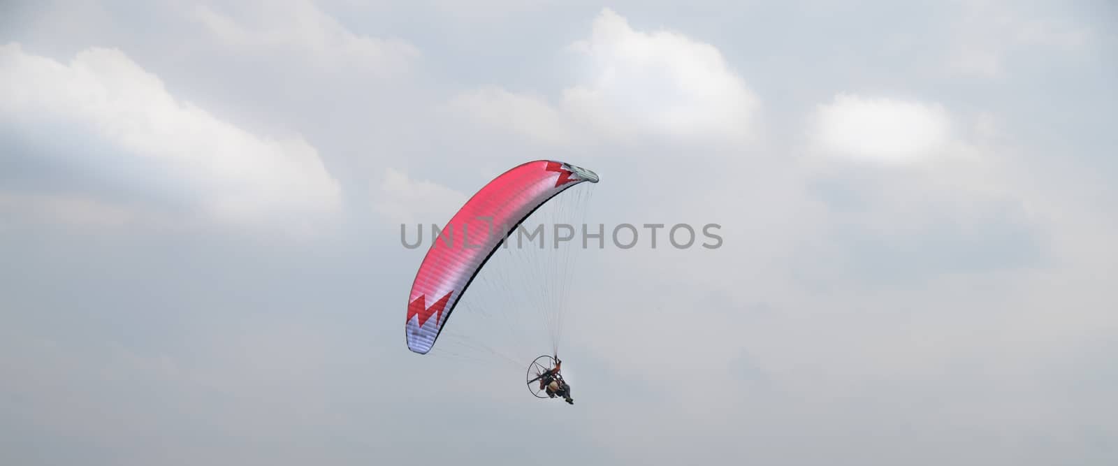 motorized paraglider flying in the blue sky