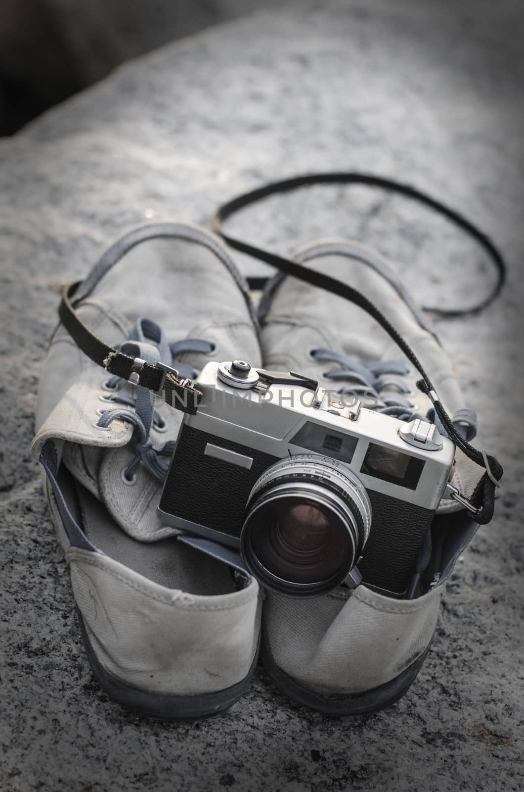 Vintage film camera on shoes with texture overlay  by pixbox77