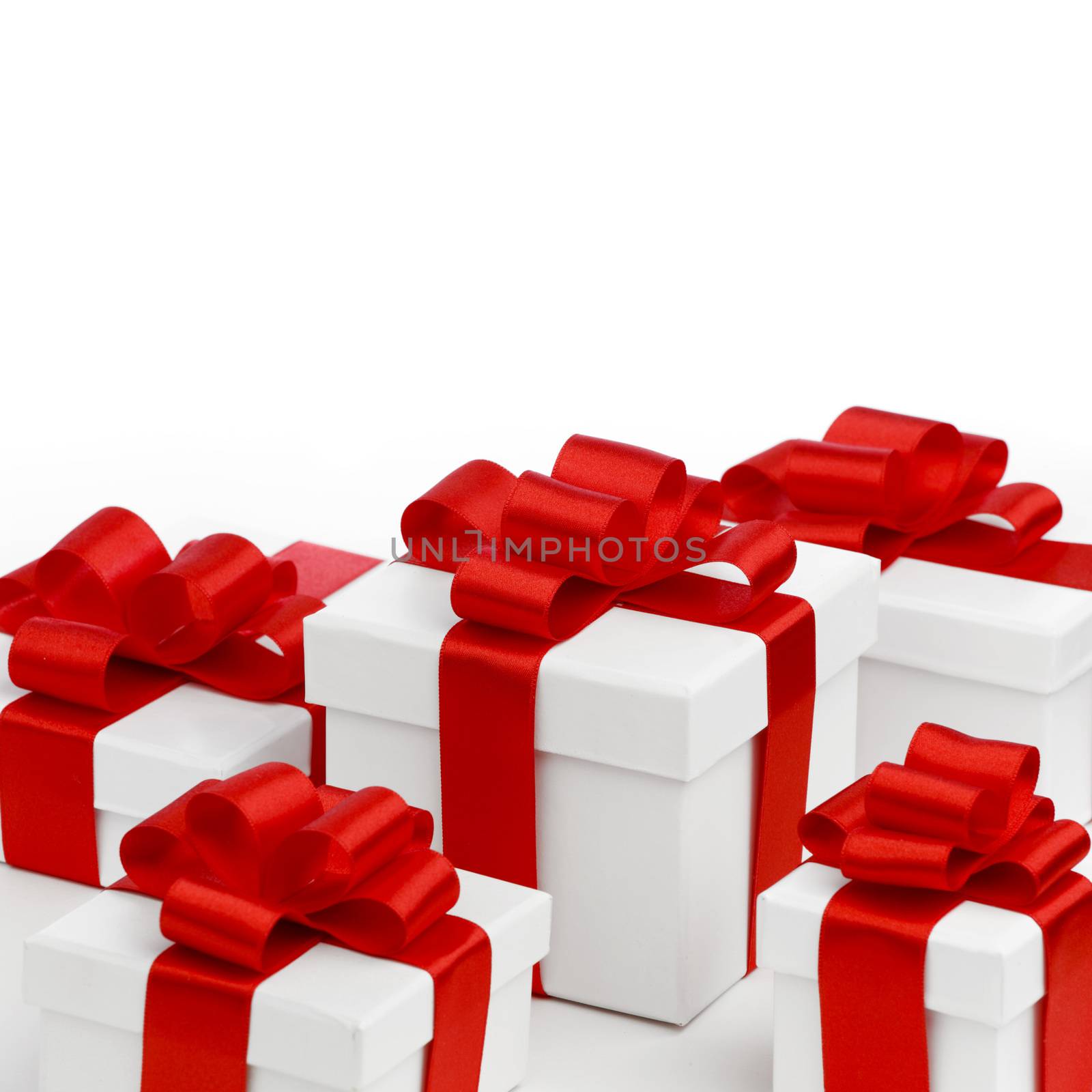 Holiday presents wrapped in white paper with red ribbons, isolated on white