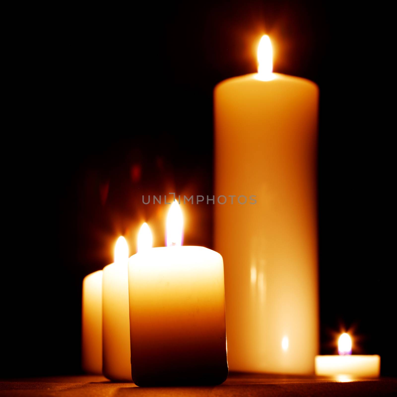 Group of burning candles isolated on black background