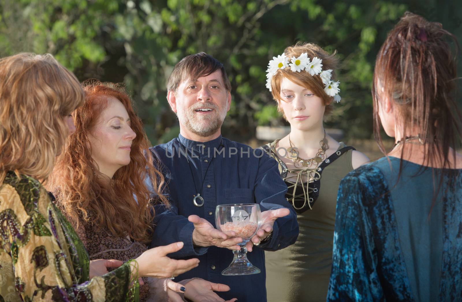 Happy bearded man with women offering a ritual goblet