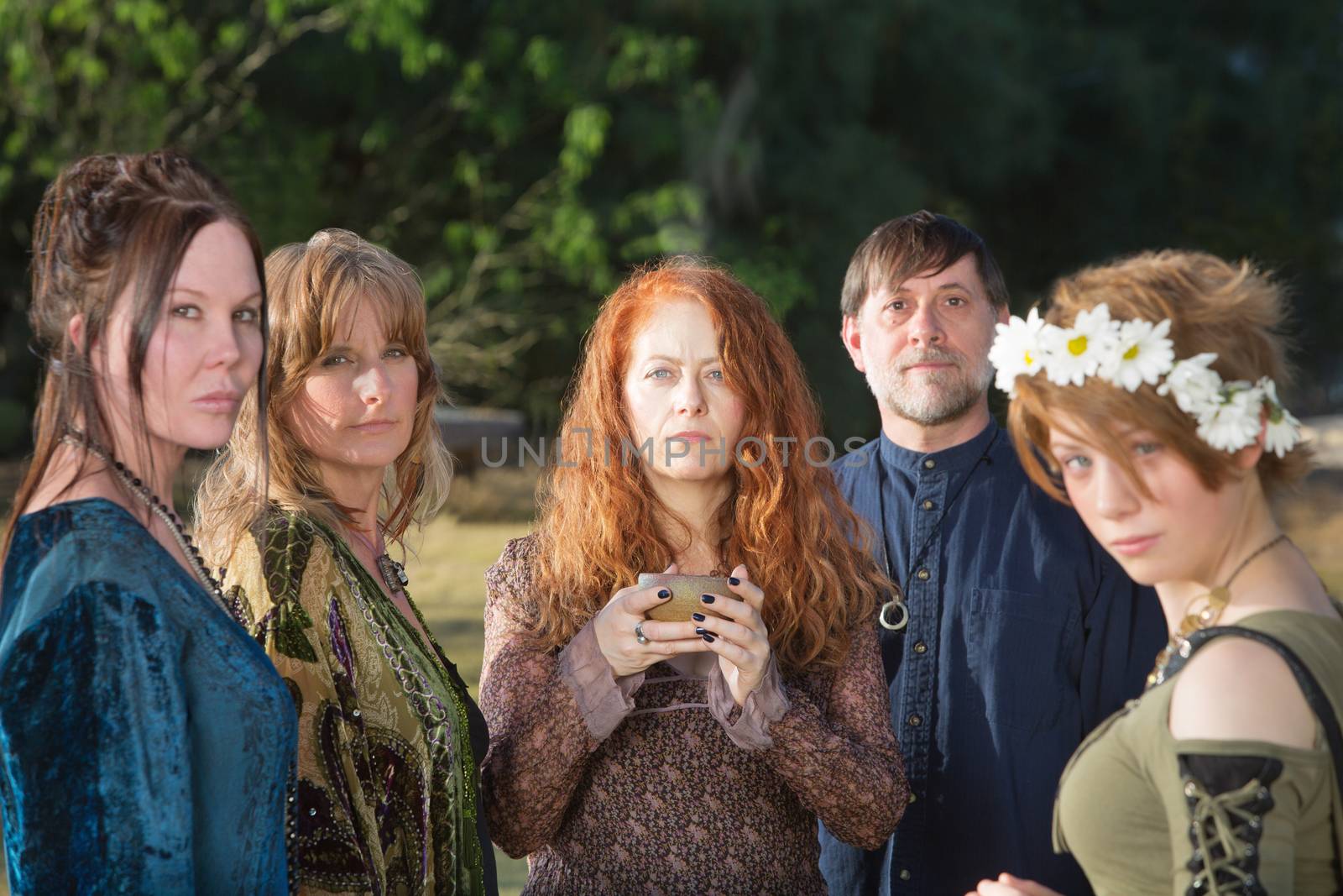 Adults in Wicca ceremony outdoors with incense bowl