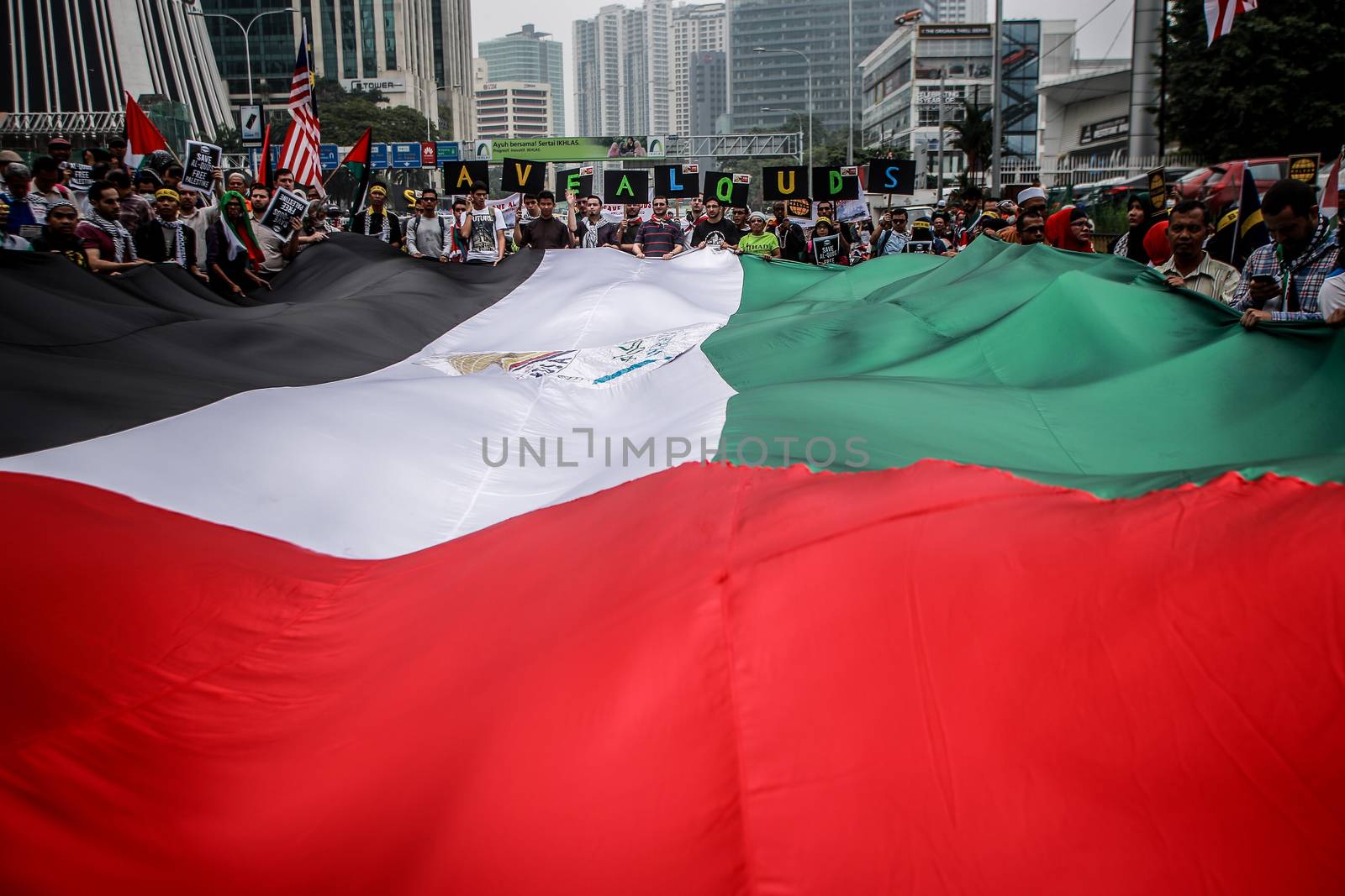 MALAYSIA, Kuala Lumpur: Demonstrators hold up a large flag during a rally in front of US Embassy in Kuala Lumpur, Malaysia on October 2, 2015. Protesters urge Americans to act against its ally Israel following clashes at Al-Aqsa mosque, between Israeli security forces and Palestinians Muslims.These pictures show hundreds of people holding signs, banners and waving flags as they parade in the Malaysian capital.
