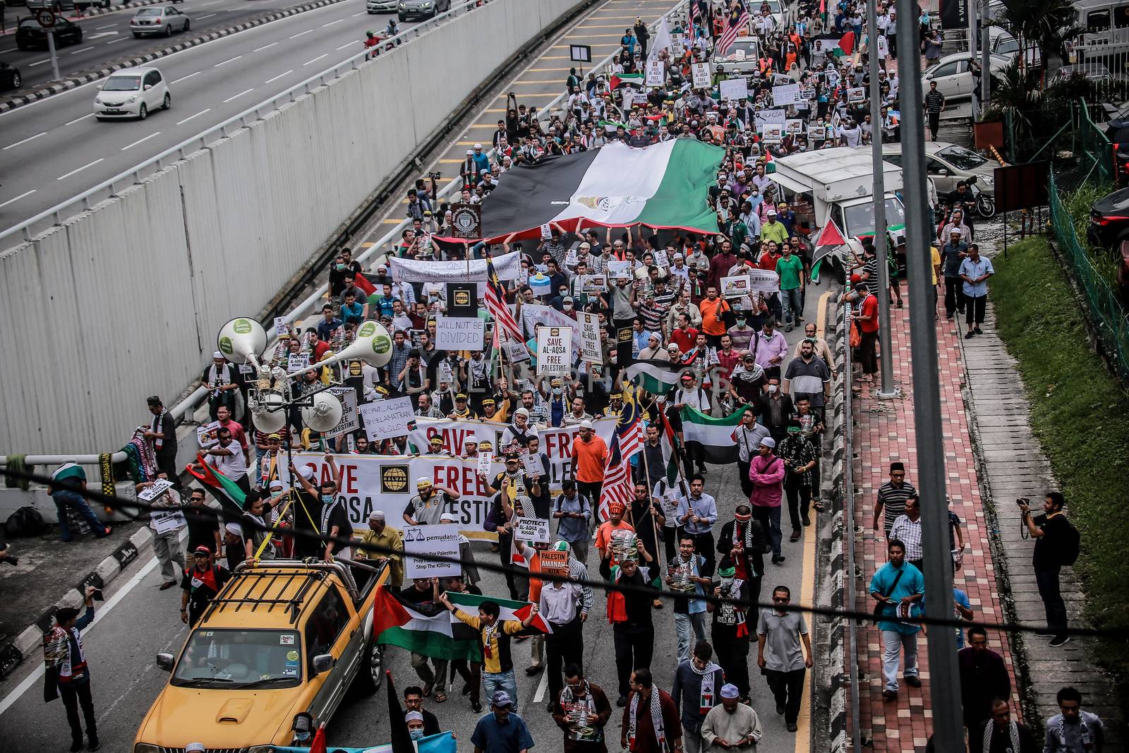 MALAYSIA, Kuala Lumpur: A wide shot of hundreds of demonstrators marching in front of US Embassy in Kuala Lumpur, Malaysia on October 2, 2015. Protesters urge Americans to act against its ally Israel following clashes at Al-Aqsa mosque, between Israeli security forces and Palestinians Muslims.These pictures show hundreds of people holding signs, banners and waving flags as they parade in the Malaysian capital.