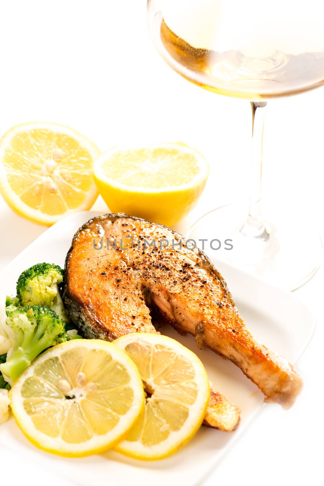 Grilled salmon and vegetables on plate vertical with wine by Nanisimova