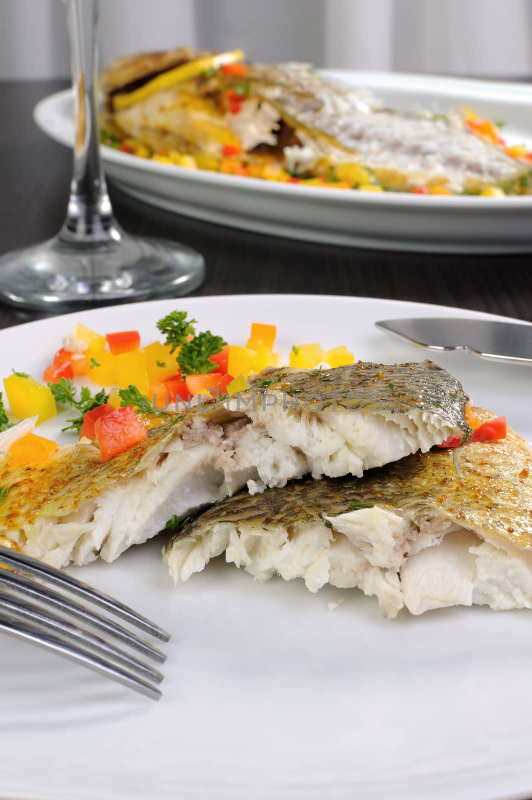 Slices of baked fish dorado with multi-colored pepper diced