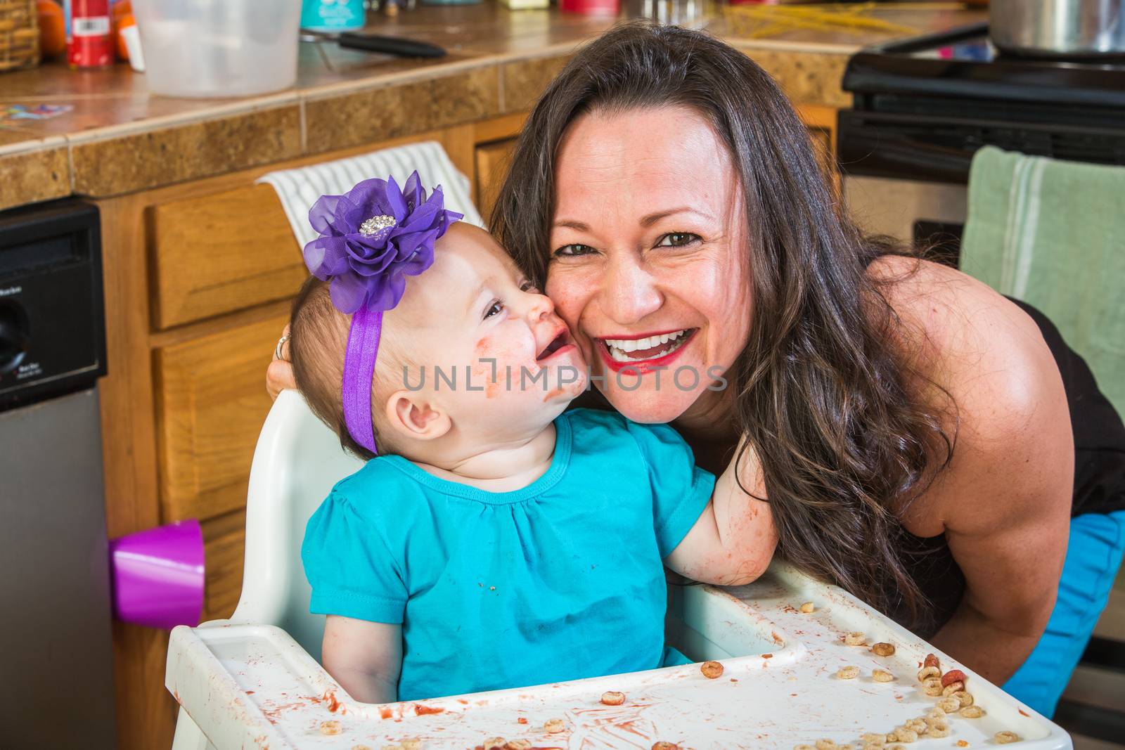 Baby girl gives her mother a kiss in the kitchen