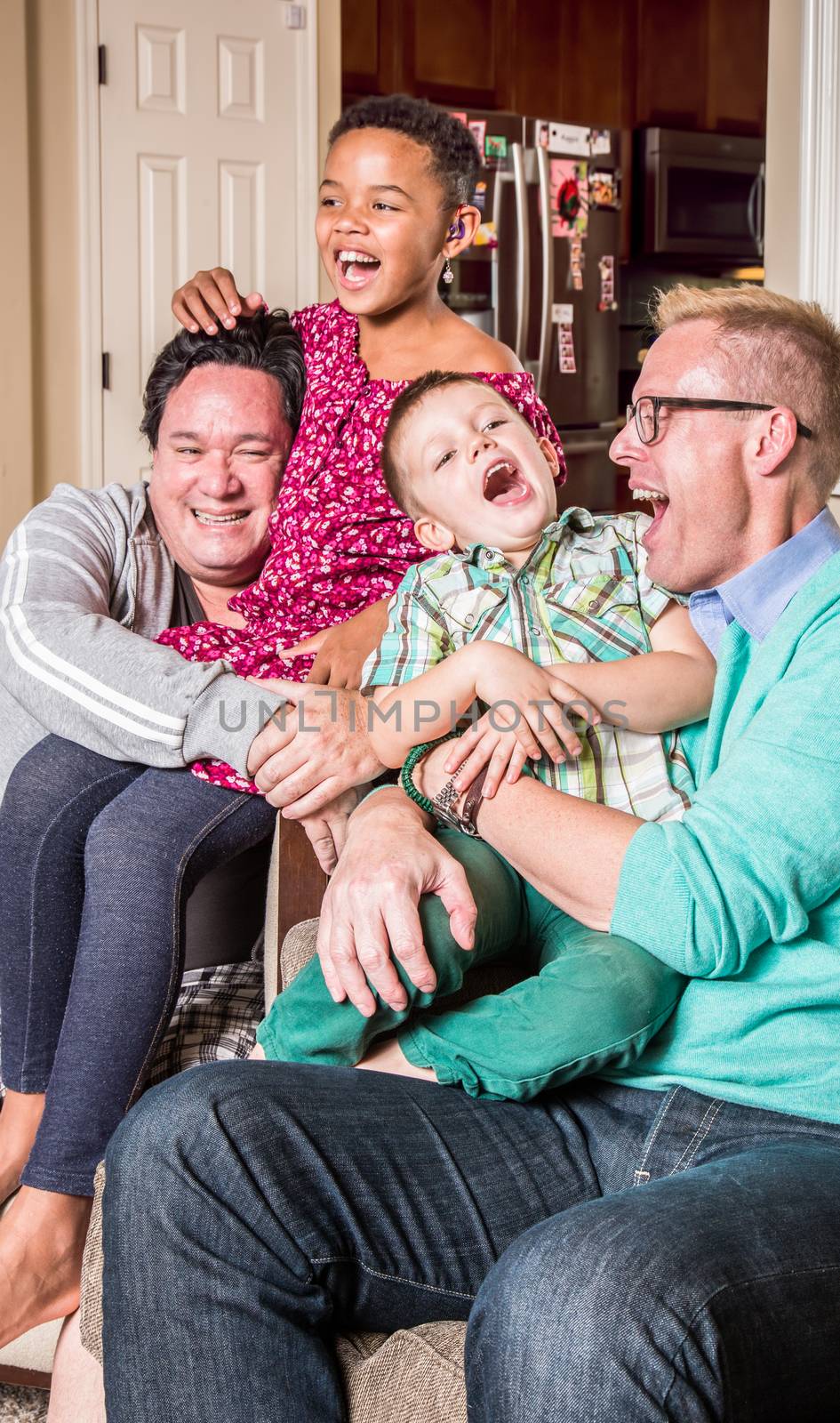 Gay parents in the living room laugh with their children