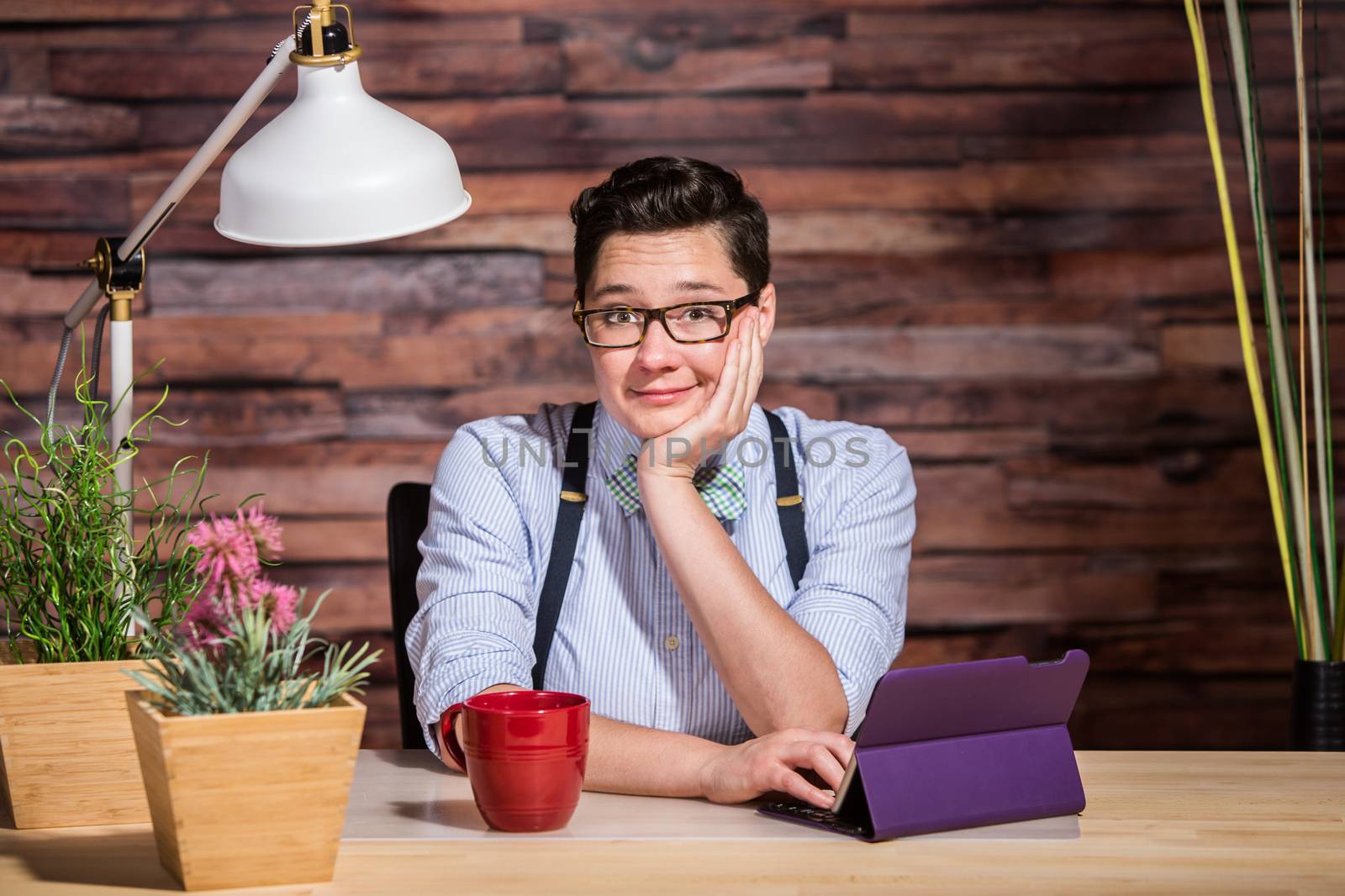 Cute smiling lesbian woman at desk with tablet computer 