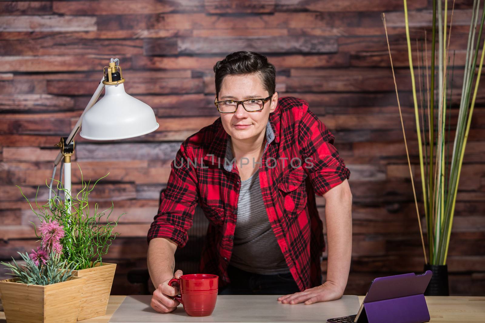 Boyish casual businesswoman standing behind desk