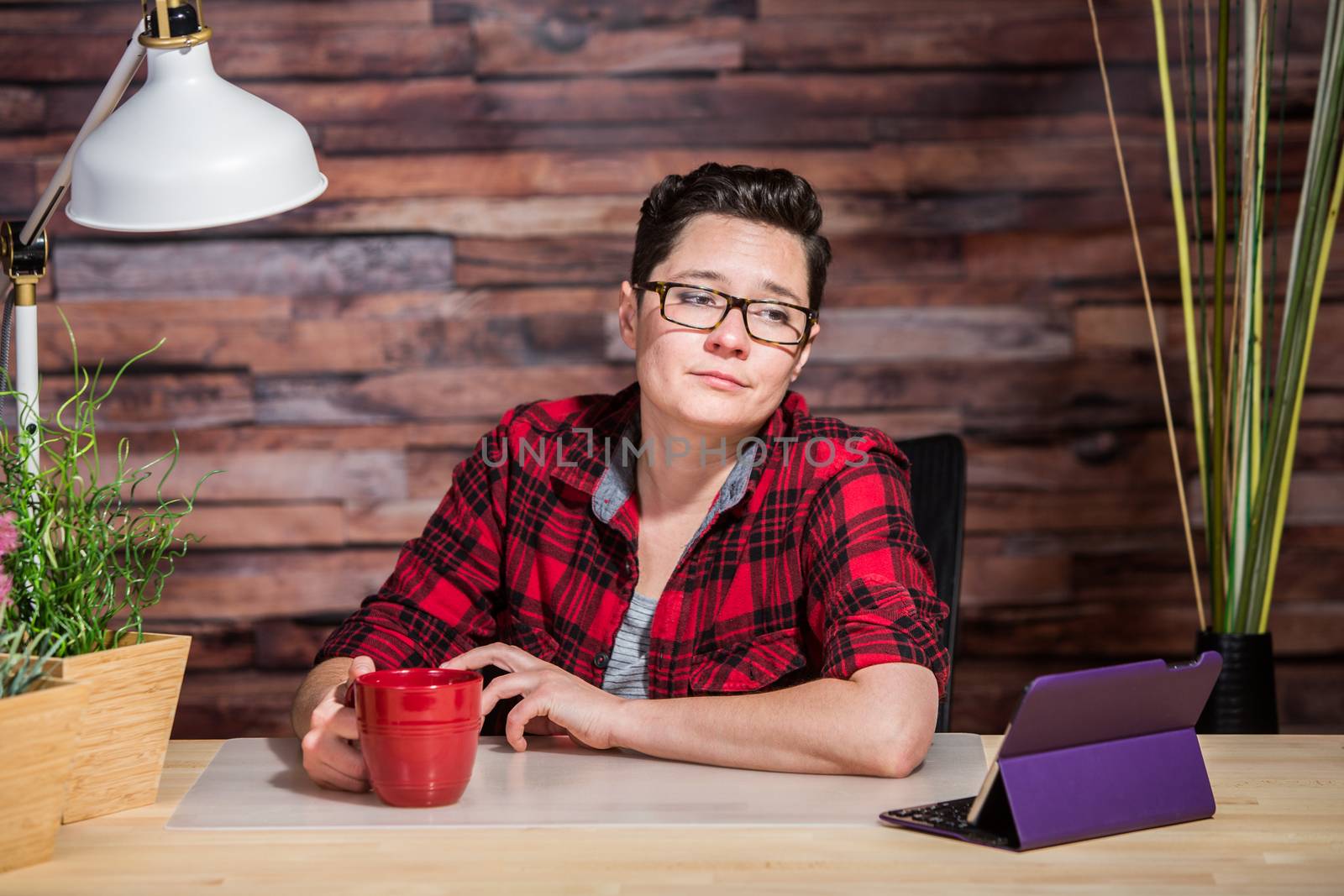 Bored woman in red shirt looking at tablet computer