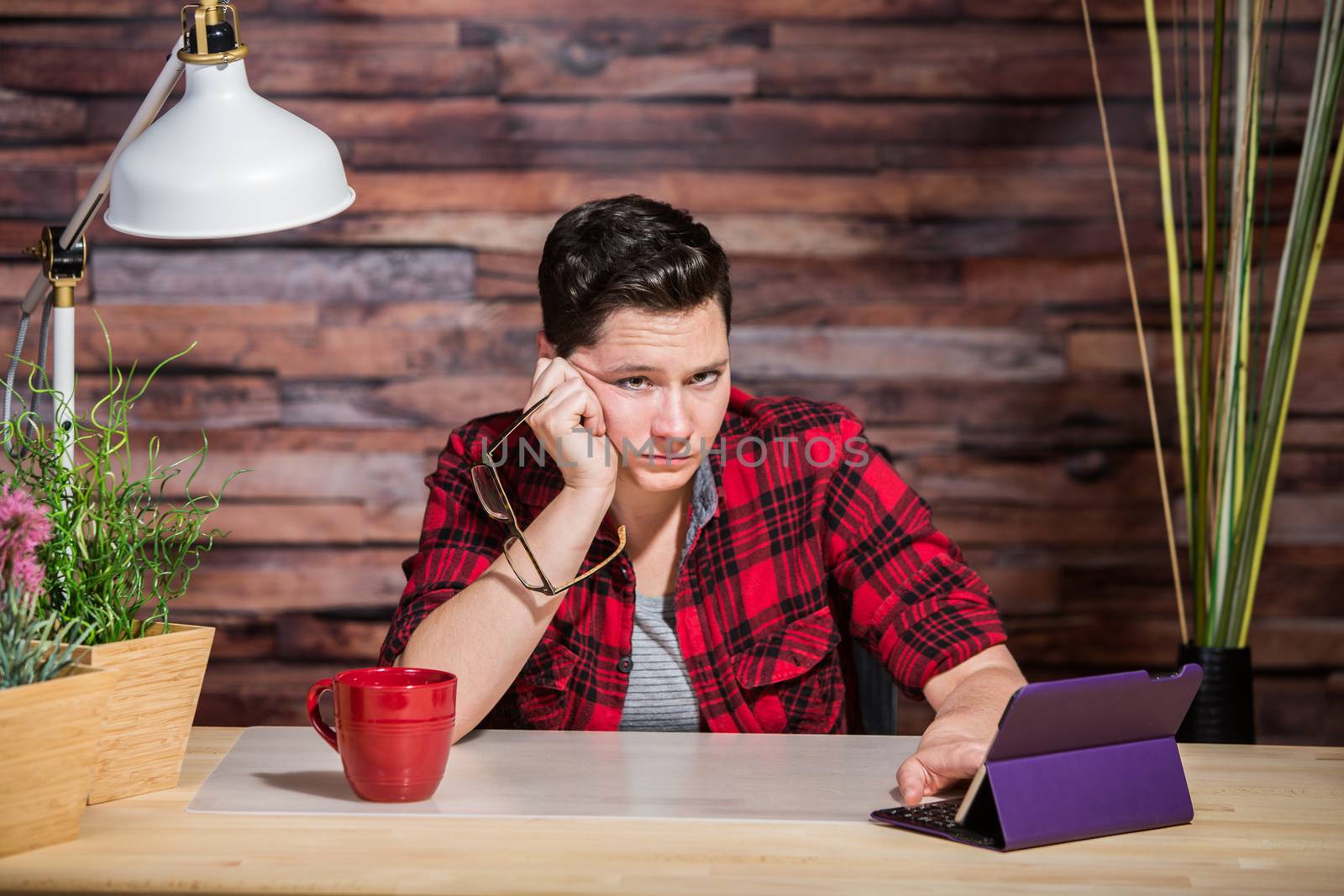 Single bored butch lady at desk with tablet computer