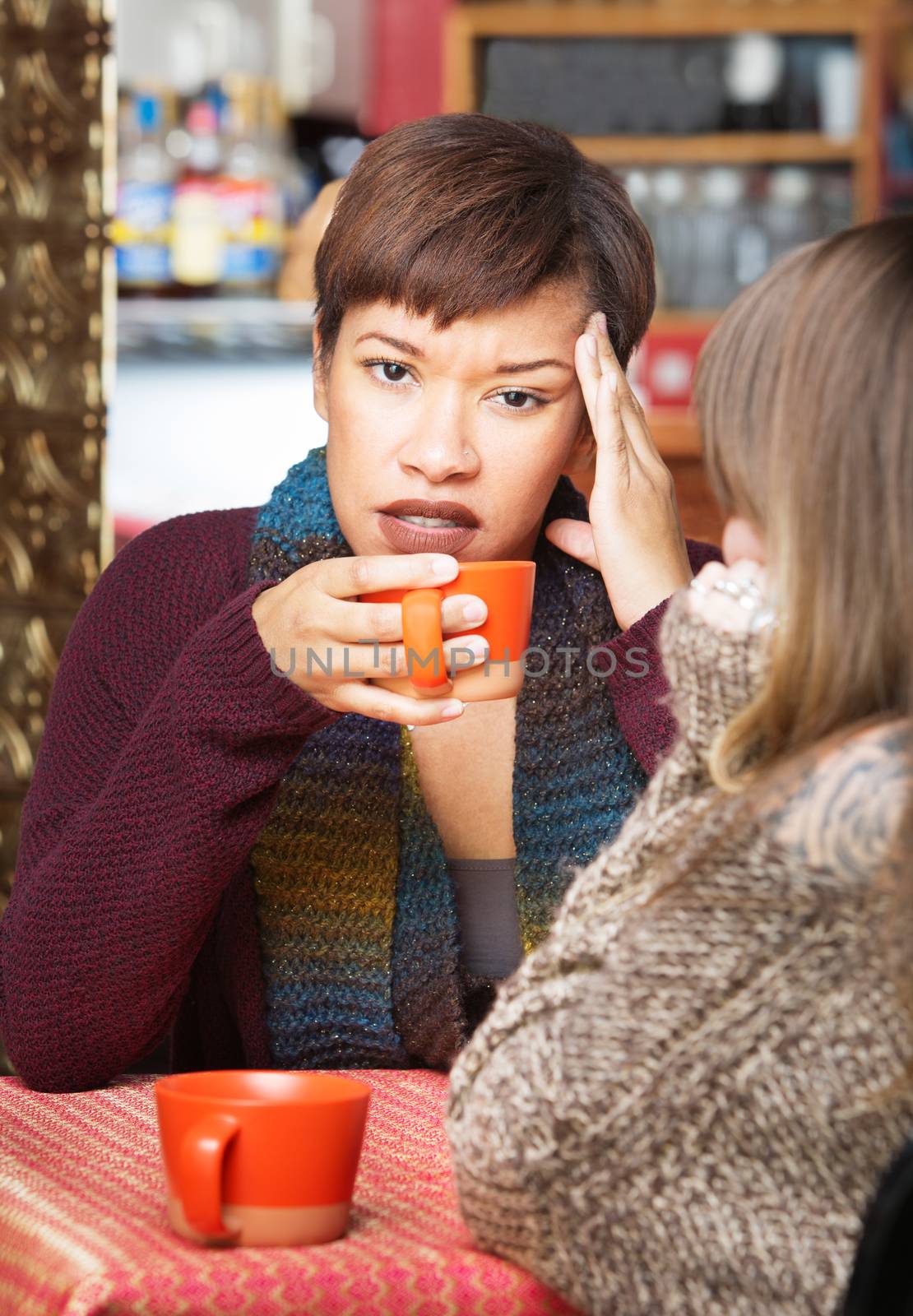Pretty young woman with headache at coffee house indoors