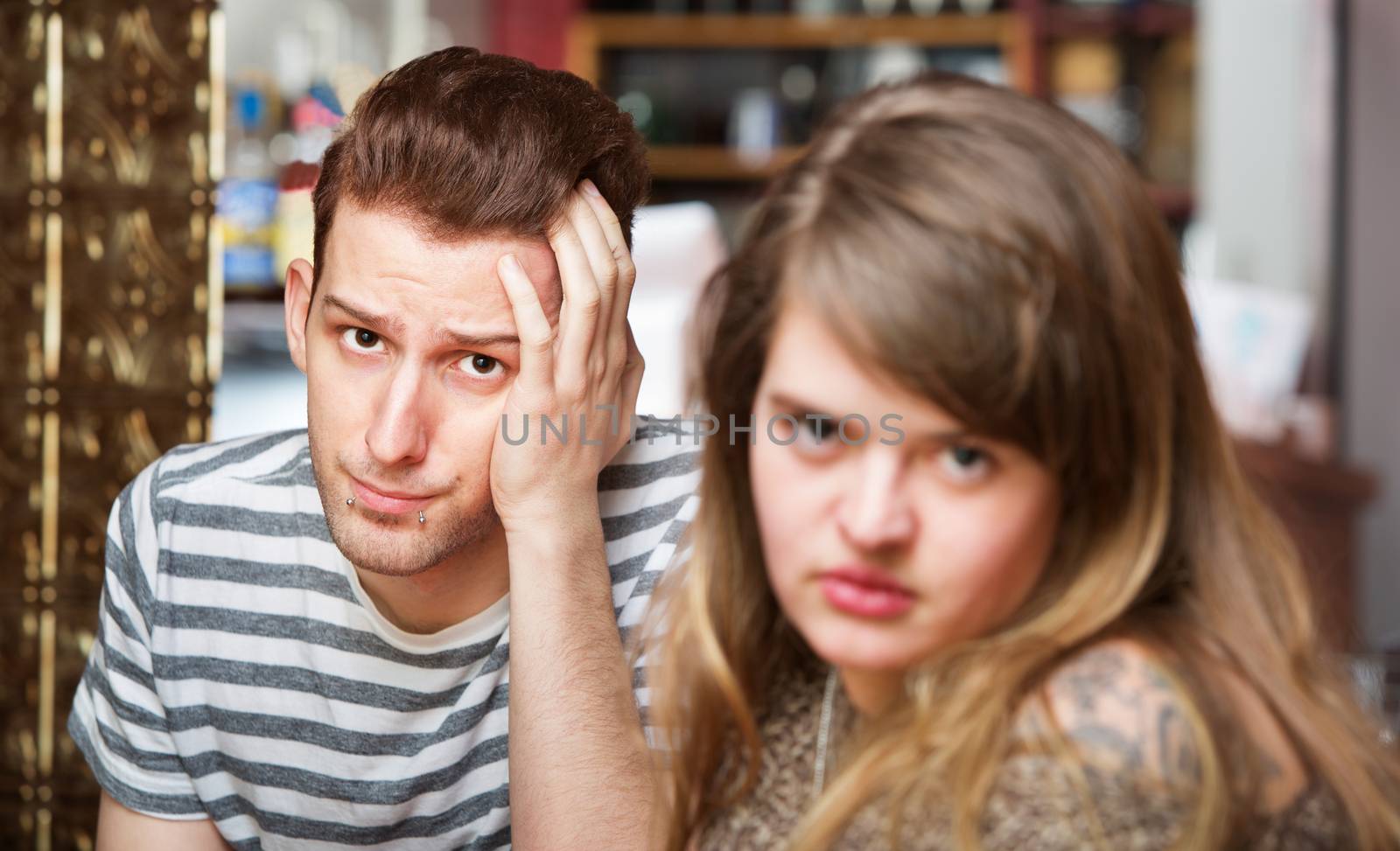 Close up of frustrated young couple in coffee house